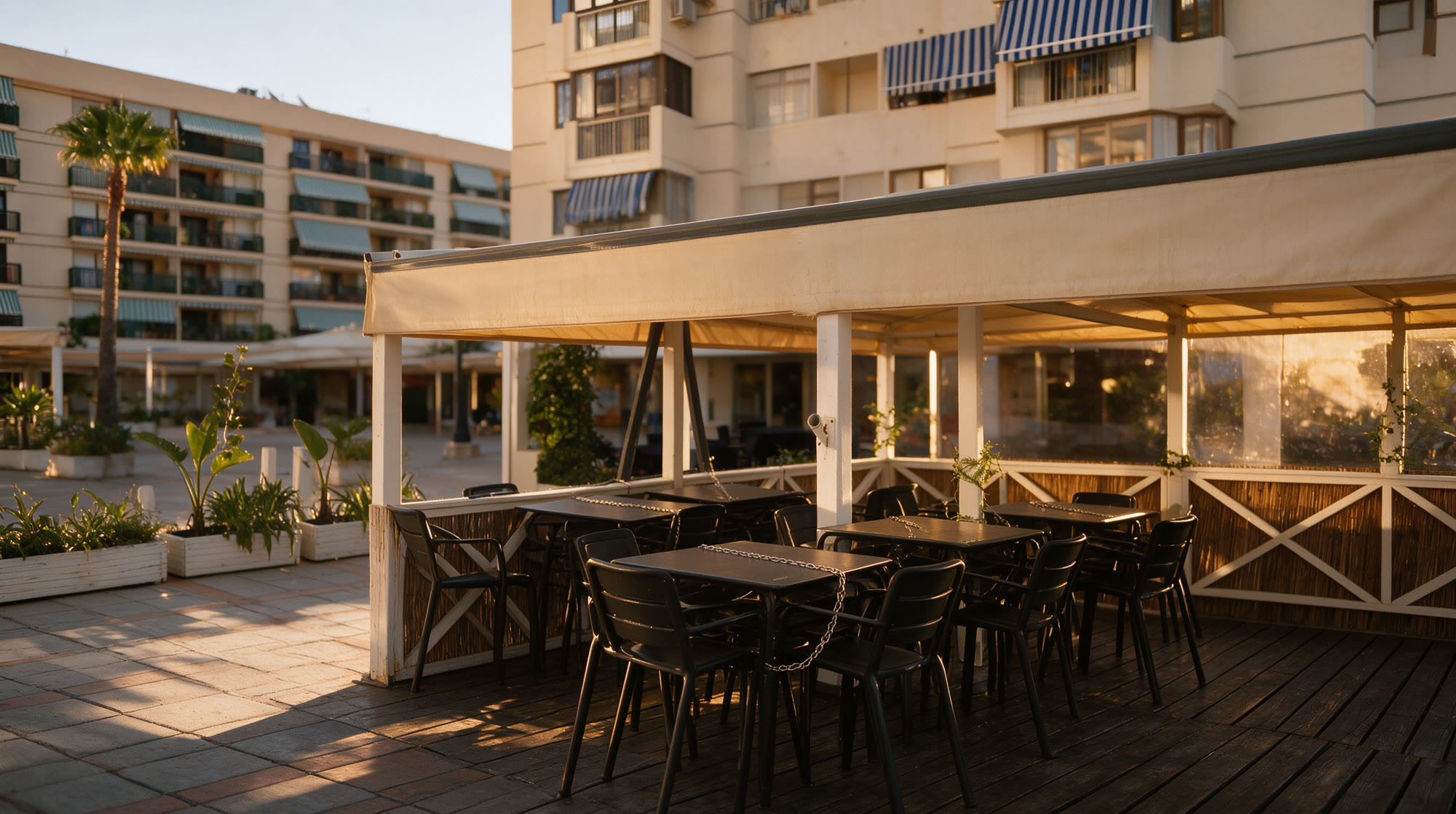 Terraza de Mesón El Caballo con mesas de madera y toldo beige